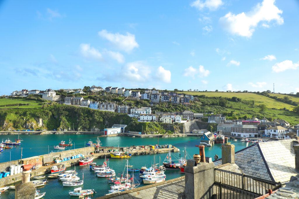 Mevagissey, Cornwall, England / UK - July 5, 2020: View of Mevagissey Harbour on a sunny Summer day with colourful fishing boat. Cornwall, UK